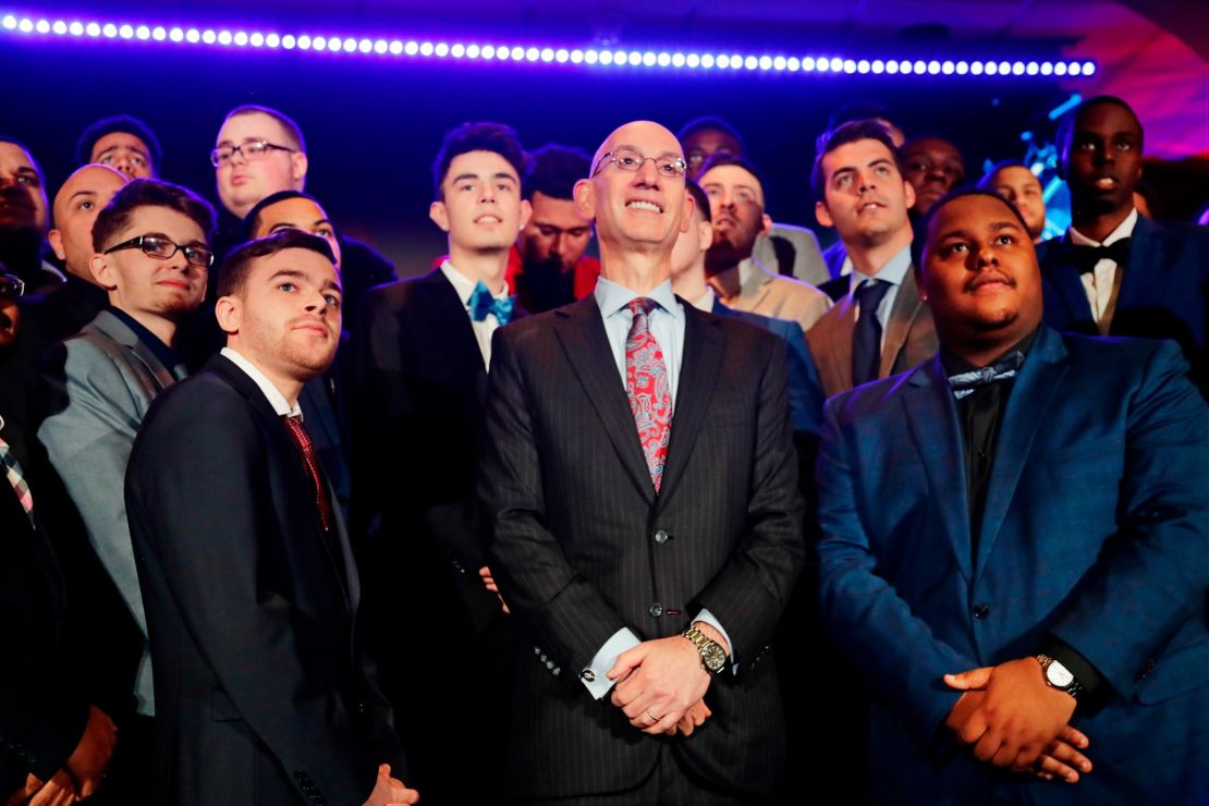 NBA Commissioner Adam Silver, center, poses for photographs with gamers at the NBA 2K League draft in April, 2018. 