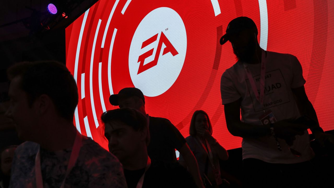 The silhouettes of attendees are seen standing in front of a Electronic Arts Inc. (EA) logo displayed on a screen during the company's EA Play event ahead of the E3 Electronic Entertainment Expo in Los Angeles, California, U.S., on Saturday, June 9, 2018. EA announced that it is introducing a higher-end version of its subscription?game-playing service that will include new titles such as Battlefield V and the Madden NFL 19 football game. Photographer: Patrick T. Fallon/Bloomberg via Getty Images