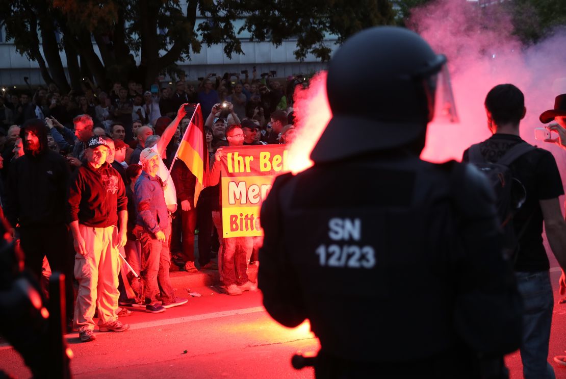 Riot police watch right-wing supporters the day after a man was stabbed to death in Chemnitz.