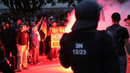 CHEMNITZ, GERMANY - AUGUST 27:  Riot police watch right-wing supporters who had gathered the day after a man was stabbed and died of his injuries on August 27, 2018 in Chemnitz, Germany. A German man died after being stabbed in the early hours yesterday following an altercation, leading a xenophobic mob of approximately 800 people to take to the streets. Today left-wing and right-wing groups of over a thousand people each confronted each other as riot police stood in between. Police announced today they have arrested a Syrian man and an Iraqi man as suspected perpetrators of the stabbing.  (Photo by Sean Gallup/Getty Images)