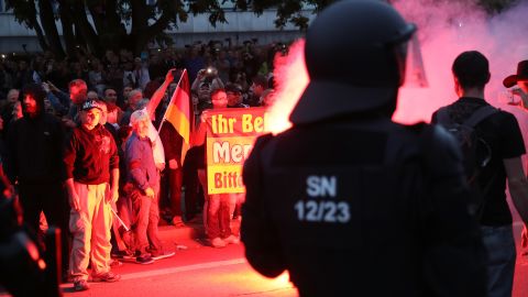 Riot police watch right-wing supporters the day after a man was stabbed to death in Chemnitz.