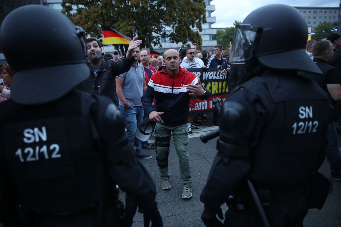 A right-wing supporter gestures to journalists as police stand by during Monday's protests in Chemnitz.