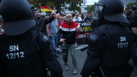A right-wing supporter gestures to journalists as police stand by during Monday's protests in Chemnitz.