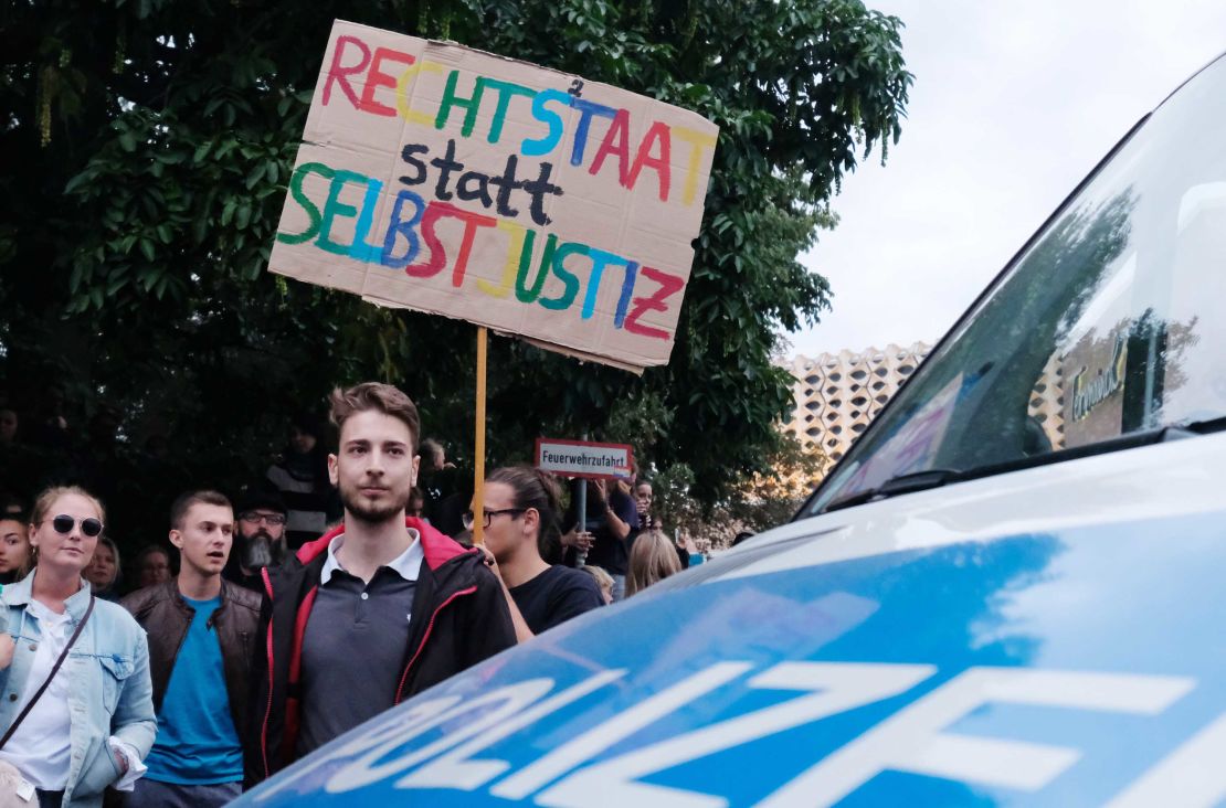 An anti-Nazi protester holds a sign reading, "Rule of law instead of vigilante justice," on Monday in Chemnitz.