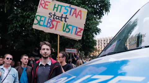 An anti-Nazi protester holds a sign reading, "Rule of law instead of vigilante justice," on Monday in Chemnitz.