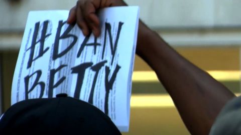 A sign at the protest shows a demonstrator's reaction to having Shelby teach such a course.