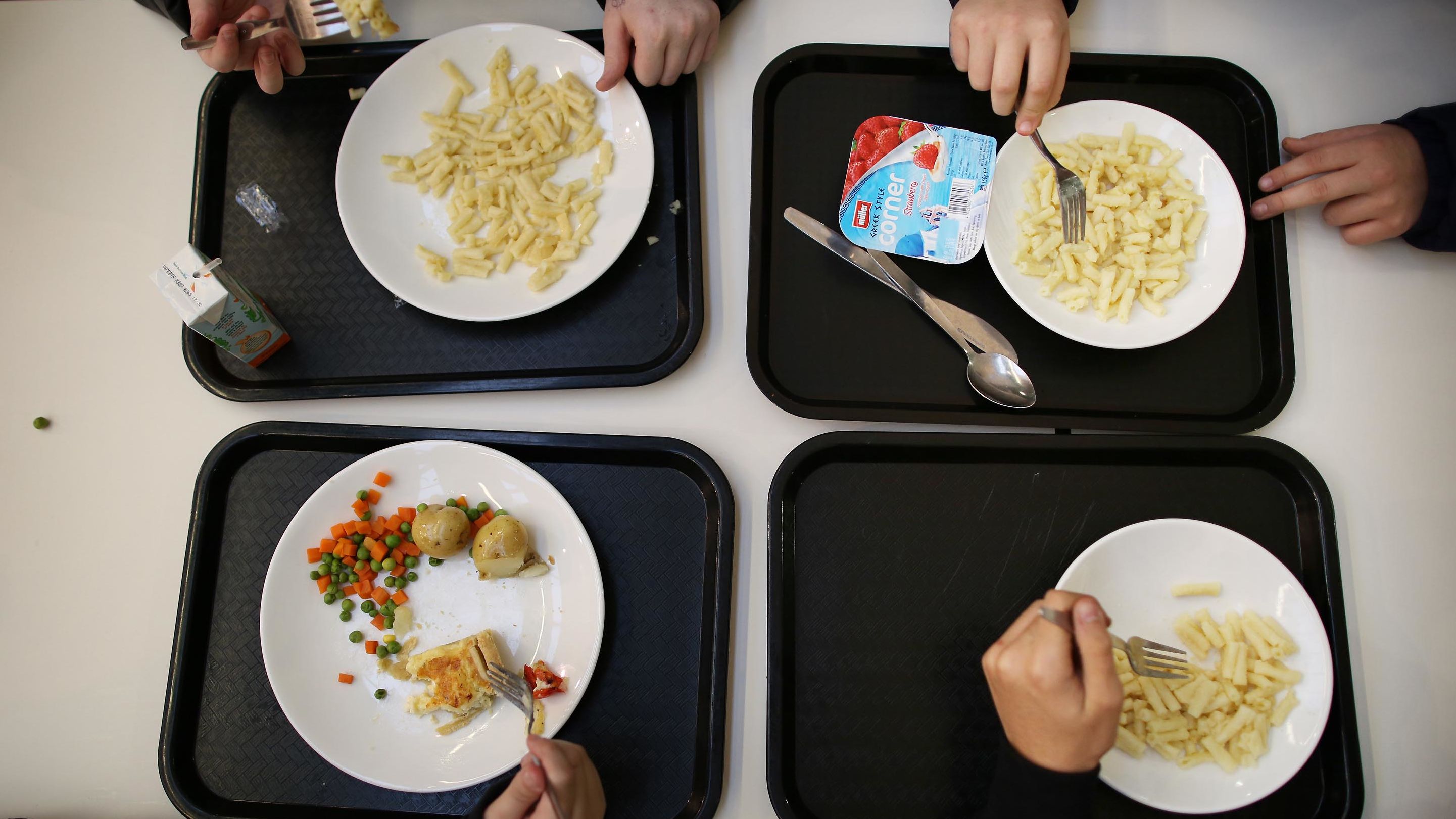 In a file photo, children eat lunch at a secondary school in London in 2014. 