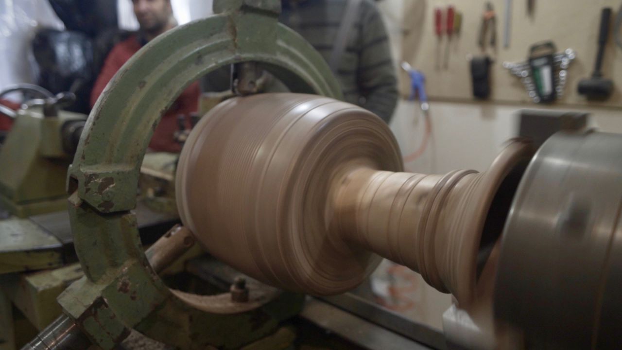 Once the wood is sufficiently dry, structural detail is carved into the drum's exterior surface -- a painstaking process carried out with a hand-powered lathe.