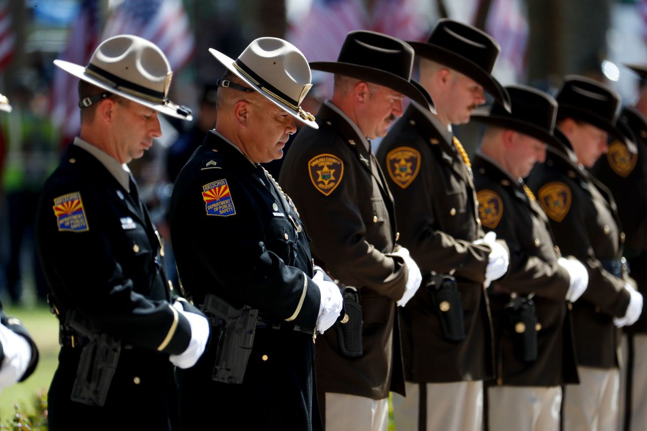 Members of Arizona law enforcement wait for the start of the memorial service in Phoenix.
