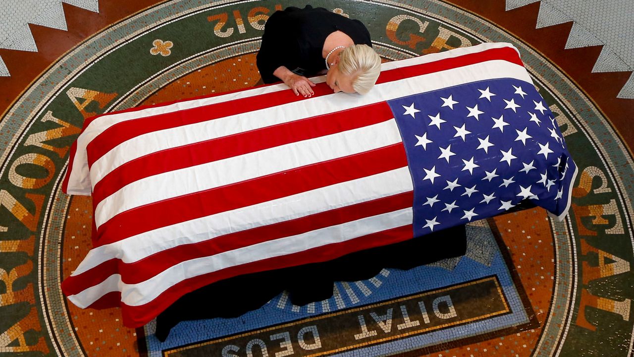 McCain's wife, Cindy, lays her head on his casket Wednesday.