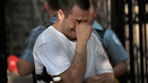 Jessie Cobos weeps as he views a memorial outside the home in Little Village.