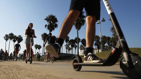 People ride Bird shared dockless electric scooters along Venice Beach on August 13, 2018 in Los Angeles, California. 