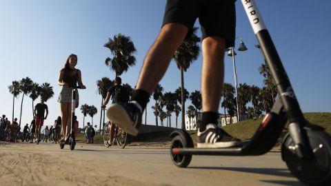 People ride Bird shared dockless electric scooters along Venice Beach on August 13, 2018 in Los Angeles, California.