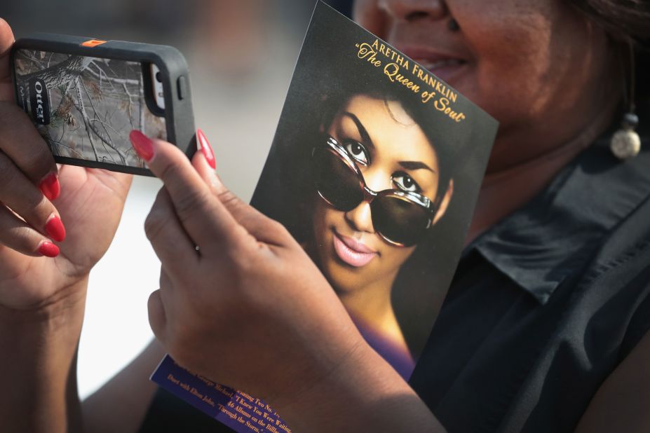 A fan takes a photograph while waiting to view Franklin's body.