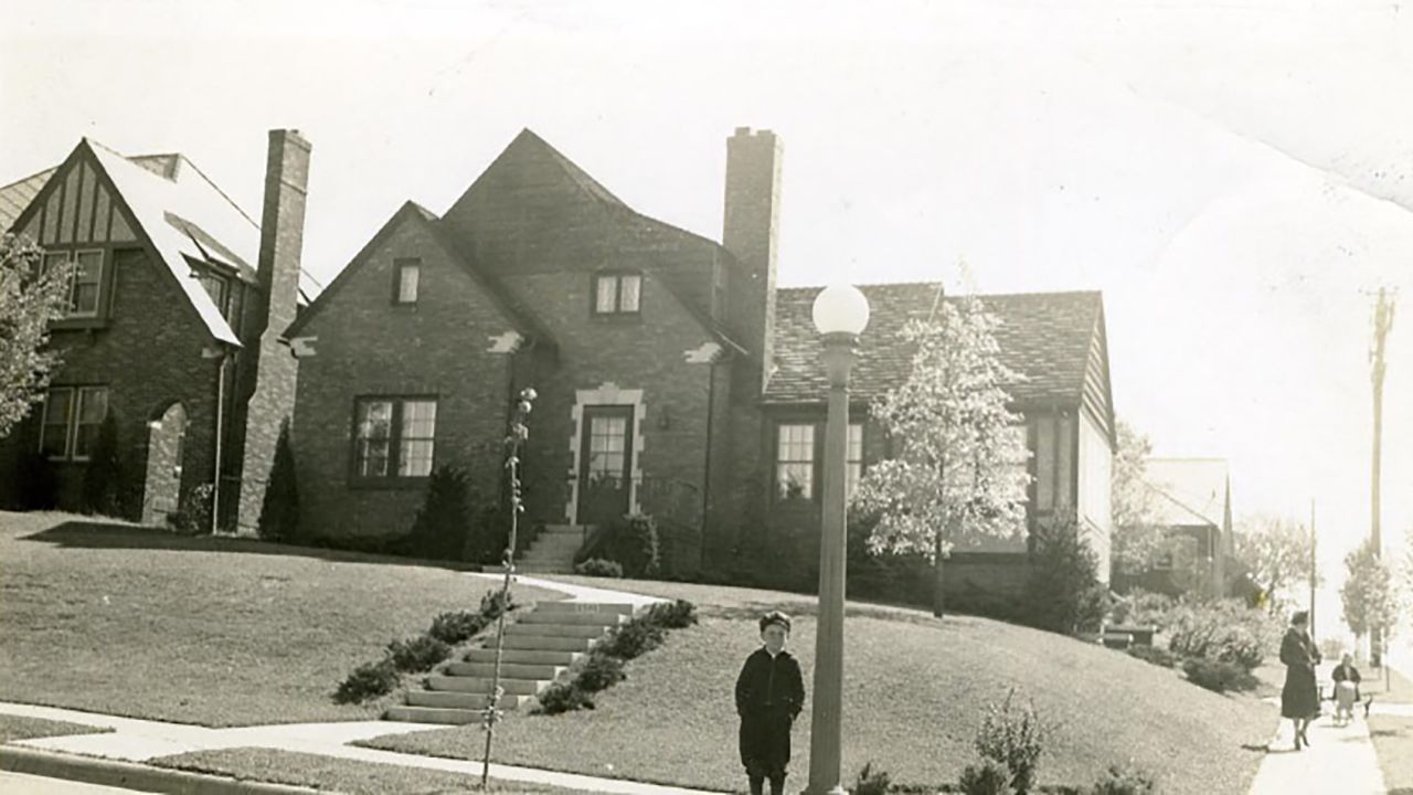 Warren Buffett stands in front of his childhood home in Omaha.