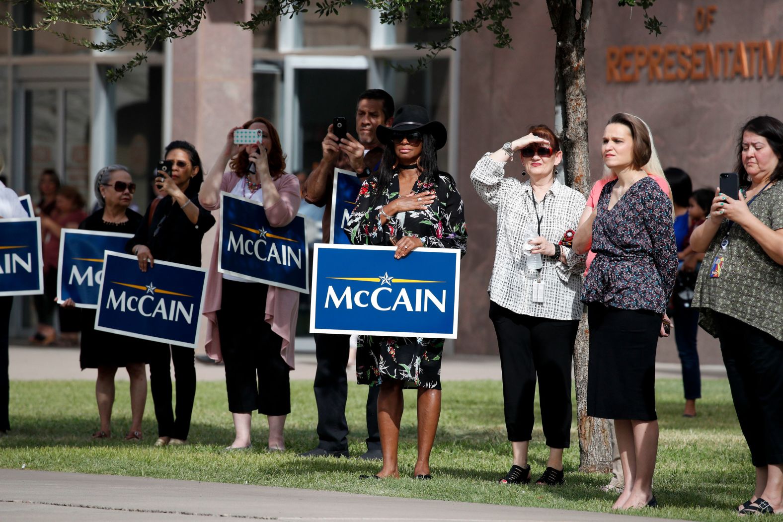 People in Phoenix watch a motorcade carrying McCain's casket on Thursday.