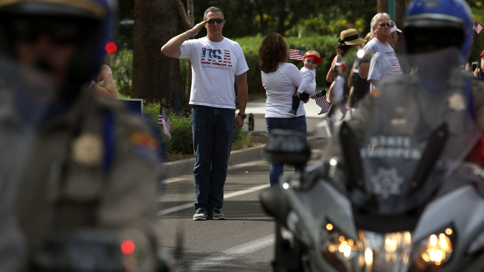 A man salutes as a hearse carrying McCain's casket travels to a memorial service at the North Phoenix Baptist Church on Thursday.