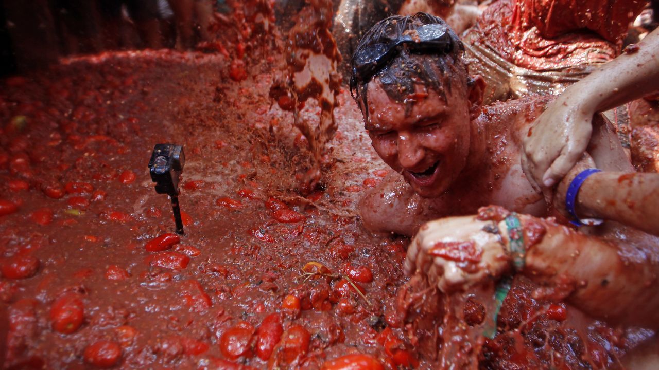 A camera films revelers as they throw tomatoes at one another Wednesday, August 29, during the annual <a href="https://www.cnn.com/travel/article/spain-la-tomatina-2015/index.html" target="_blank">Tomatina festival</a> in Bunol, Spain.