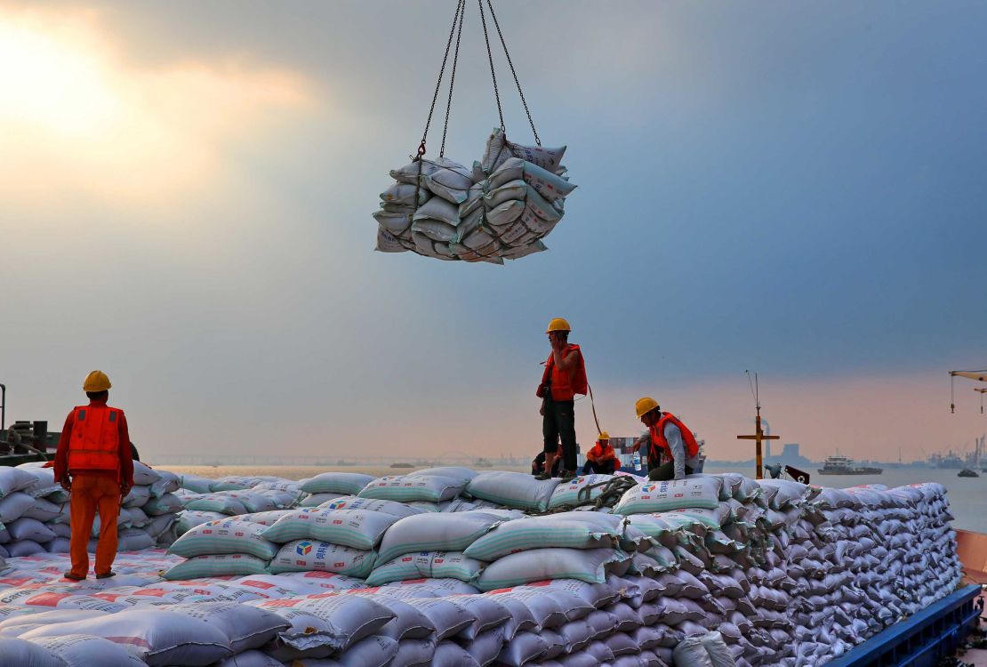 Workers transporting bags of soybean meal at a dockyard in Jiangsu province.