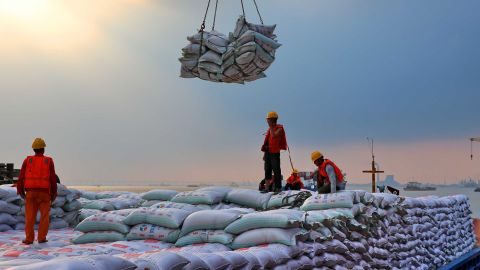 Workers transporting bags of soybean meal at a dockyard in Jiangsu province.