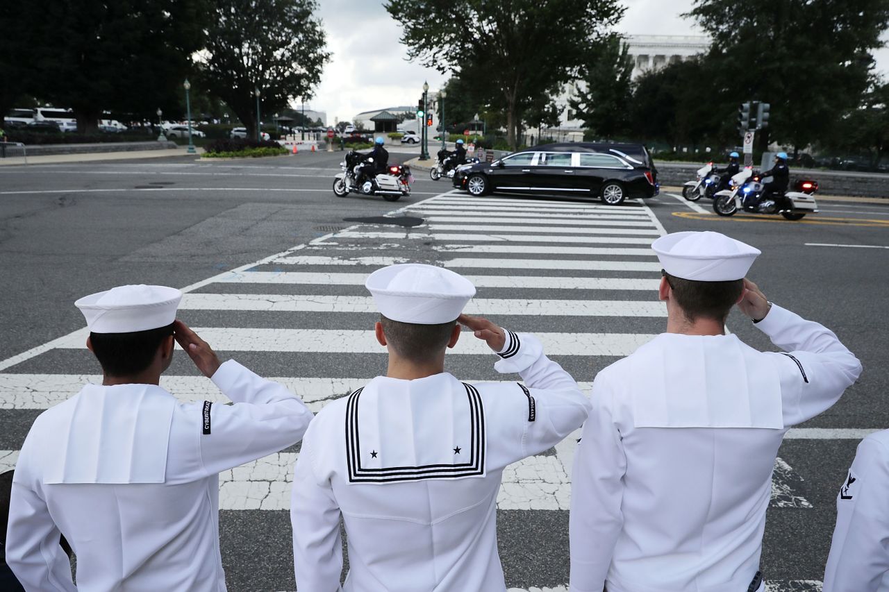 Navy sailors salute as McCain passes by in Washington.