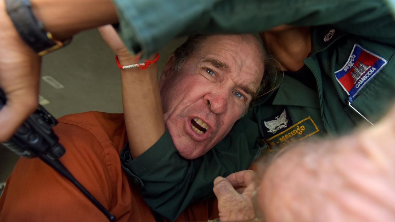 Australian filmmaker James Ricketson attempts to speak to journalists after being found guilty of espionage in Cambodia.