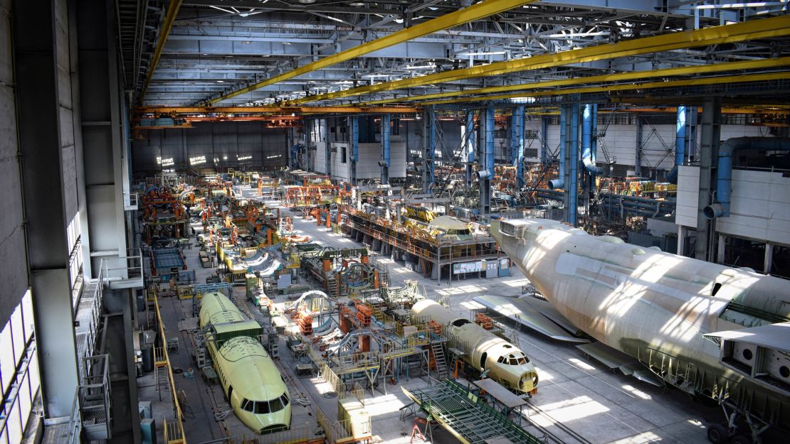 The An-255 is stored in a huge hangar alongside other semi-built aircraft.