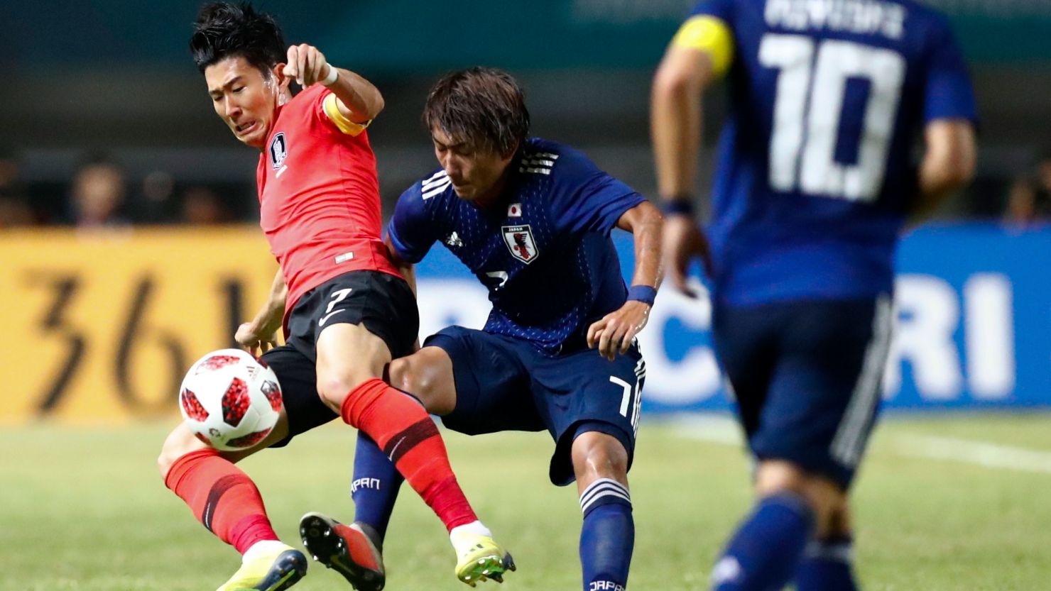 South Korea's Son Heung-min, left, duels for the ball against Japan's Teruki Hara during Saturday's match.