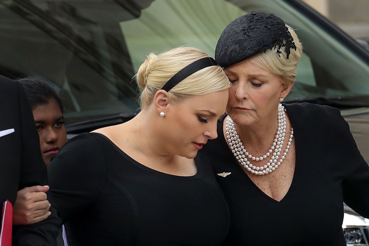 Meghan McCain and her mother embrace as the senator's casket arrives at the National Cathedral.