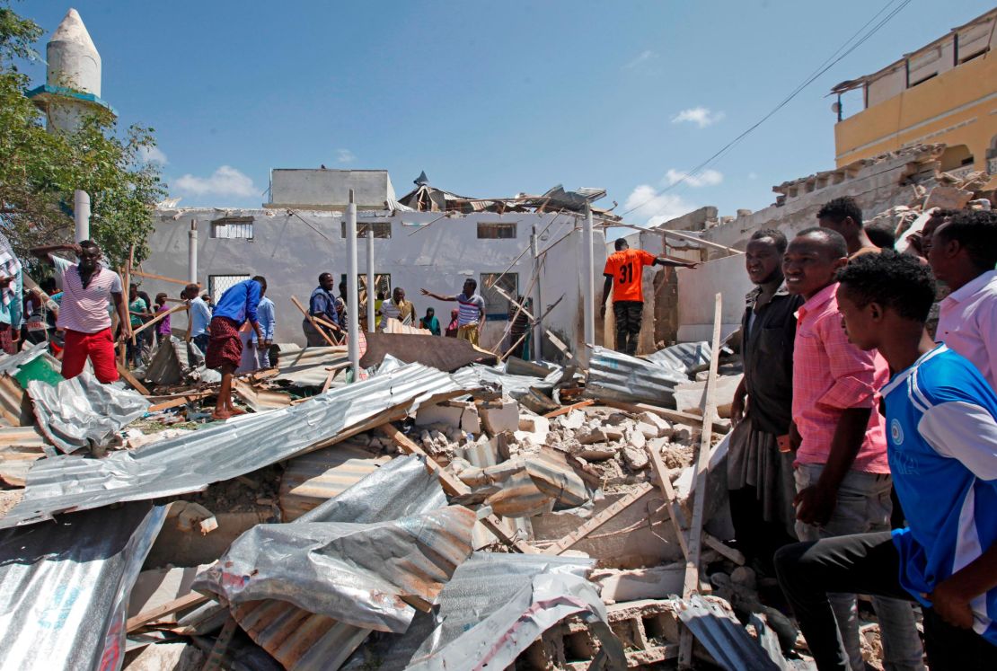 Somalis search wreckage at the scene of a blast outside the compound of a district headquarters in Mogadishu, Somalia, on Sunday, September 2. 