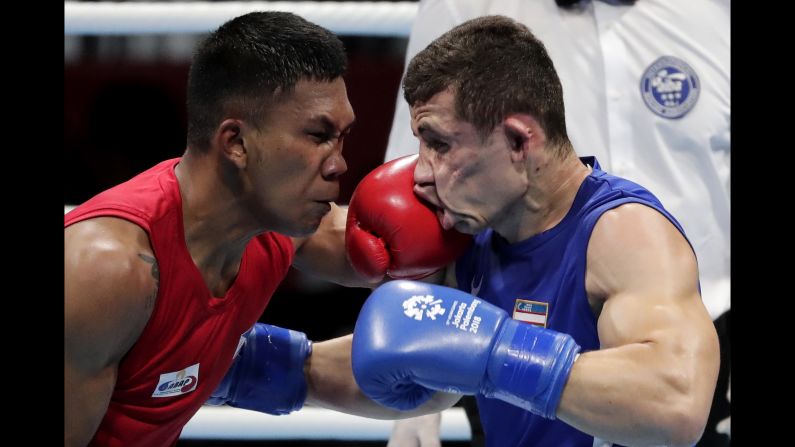 Phillippines' Eumir Felix Marcial, left, and Uzbekistan's Israil Madrimov fight in their men's middleweight boxing semifinal on Friday, August 31.