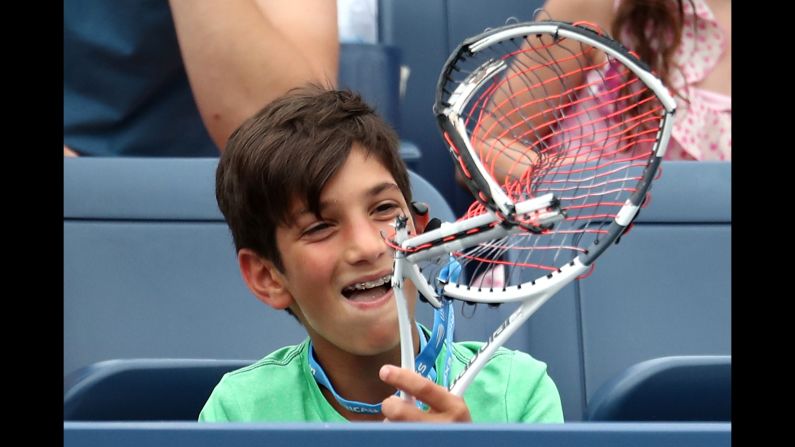 A young fan receives a broken racquet from Austria's Dominic Thiem during the US Open men's singles third round on Friday, August 31.