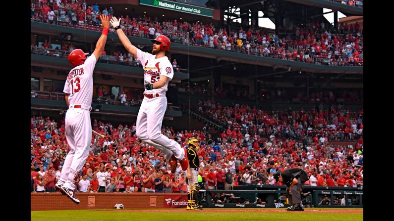 St. Louis Cardinals starting pitcher John Gant leaps to high-five third baseman Matt Carpenter after hitting a solo home run off of Pittsburgh Pirates starting pitcher Joe Musgrove during the fourth inning at Busch Stadium on Friday, August 31.