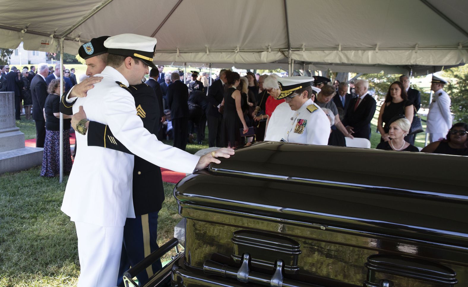 McCain's son Jimmy hugs his brother Jack during the private burial service.