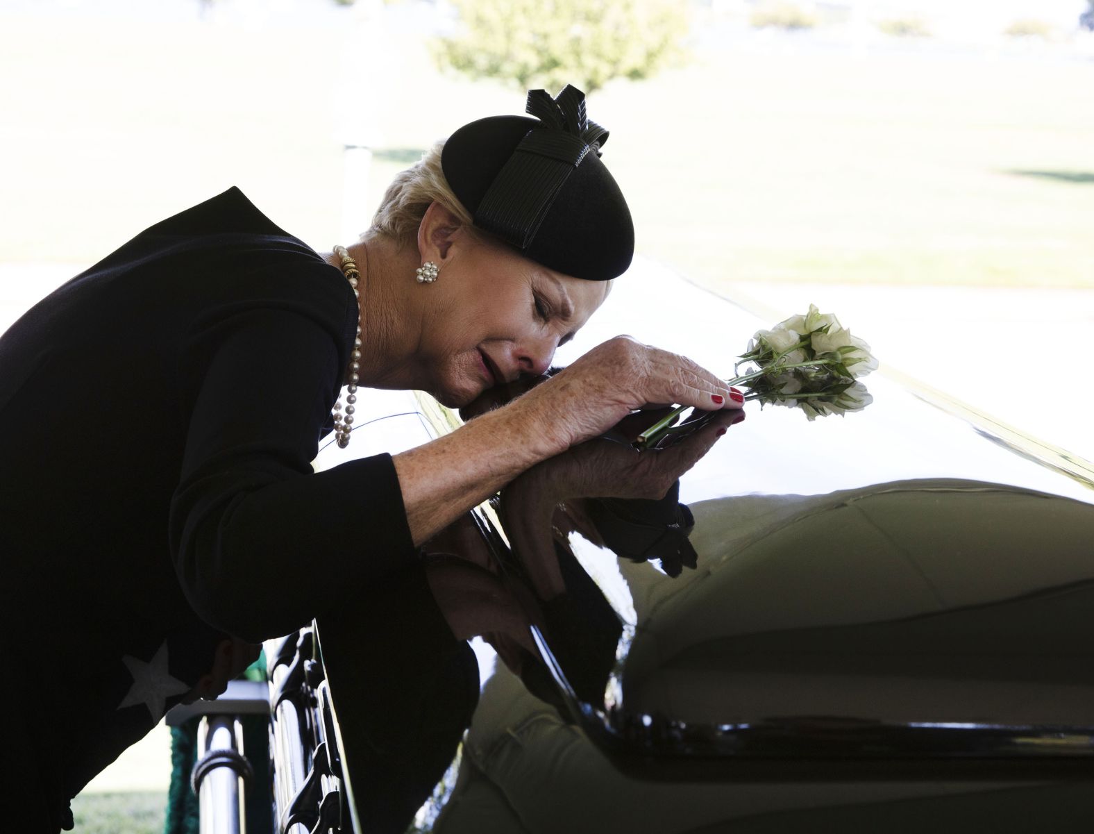 McCain's wife, Cindy, lays her head on her husband's casket during his burial service on Sunday.