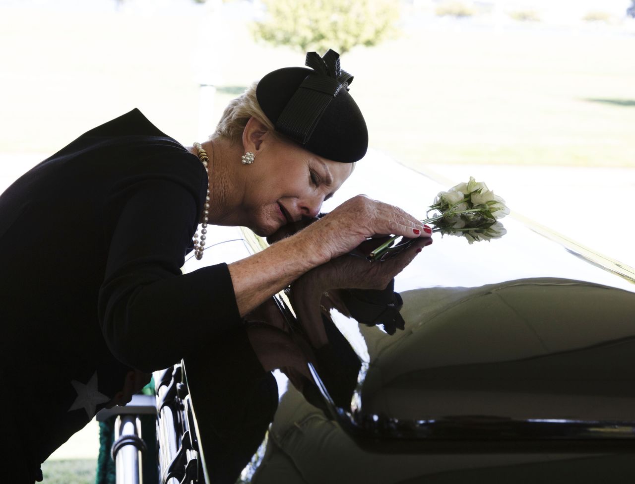 McCain's wife, Cindy, lays her head on her husband's casket during his burial service on Sunday.