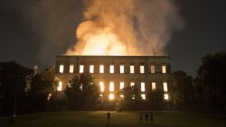 People watch as flames engulf the 200-year-old National Museum of Brazil, in Rio de Janeiro, Sunday, Sept. 2, 2018. According to its website, the museum has thousands of items related to the history of Brazil and other countries. The museum is part of the Federal University of Rio de Janeiro. (AP Photo/Leo Correa)