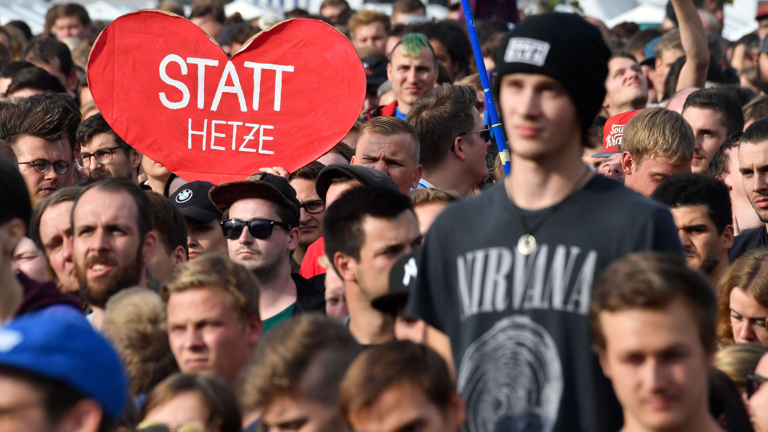 A crowd member holds a sign reading "Instead of hate" at the concert in Chemnitz.