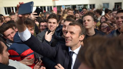 French President Emmanuel Macron takes a selfie with students during a visit at the high school Therese Planiole, in Loches, central France, on March 15, 2018. 