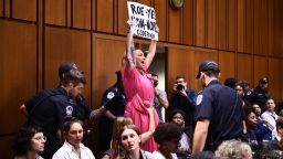 A member of Code Pink protests as US Supreme Court nominee Brett Kavanaugh arrives on the first day of his confirmation hearing in front of the US Senate on Capitol Hill in Washington DC, on September 4, 2018. - President Donald Trump's newest Supreme Court nominee Brett Kavanaugh is expected to face punishing questioning from Democrats this week over his endorsement of presidential immunity and his opposition to abortion. Some two dozen witnesses are lined up to argue for and against confirming Kavanaugh, who could swing the nine-member high court decidedly in conservatives' favor for years to come. Democrats have mobilized heavily to prevent his approval. (Photo by Brendan Smialowski / AFP)        (Photo credit should read BRENDAN SMIALOWSKI/AFP/Getty Images)