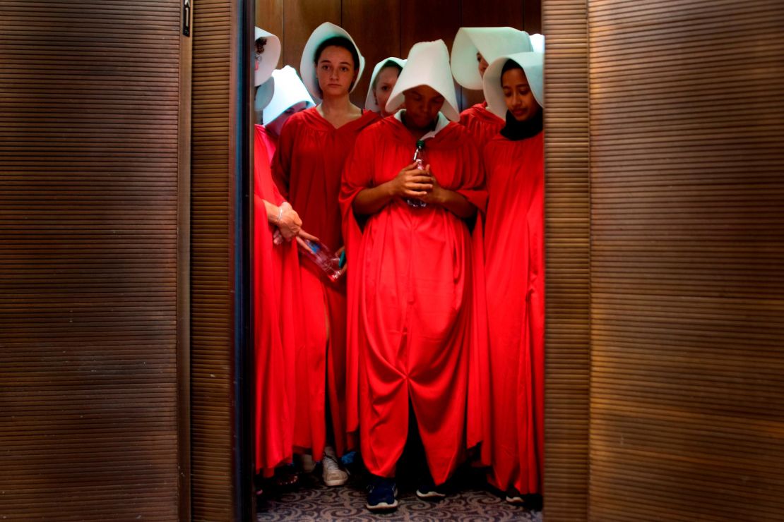 Women dressed as characters from "The Handmaid's Tale" stand in an elevator at the Hart Senate Office Building as Supreme Court nominee Brett Kavanaugh starts the first day of his confirmation hearing.