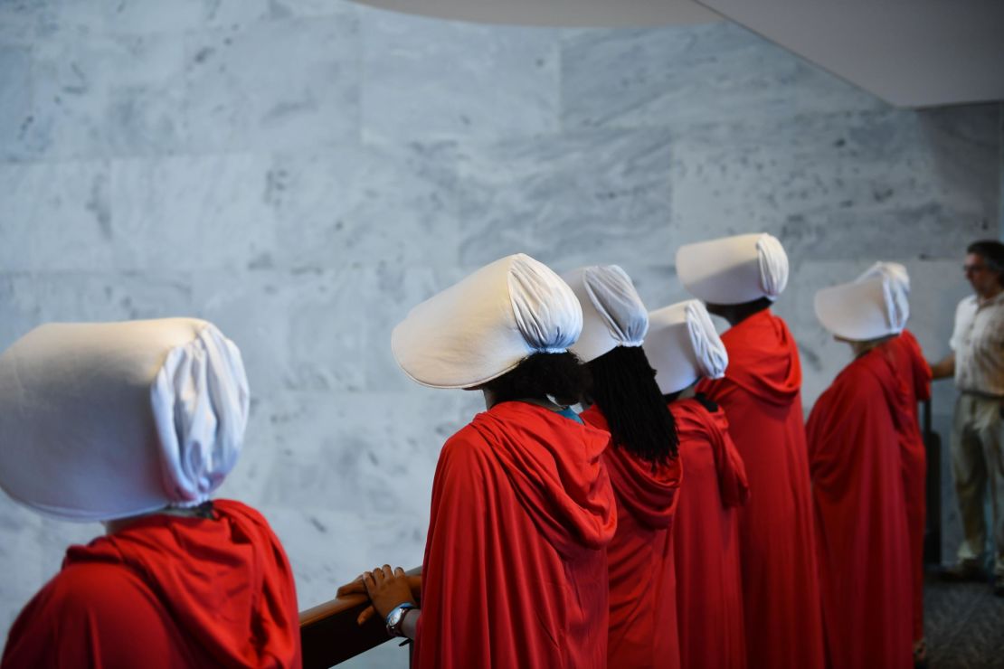 Women dressed as characters from the novel-turned-TV series "The Handmaid's Tale" line up before Supreme Court nominee Brett Kavanaugh starts the first day of his confirmation hearing in front of the US Senate on Capitol Hill in Washington DC, on September 4, 2018. 