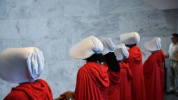 Women dressed as characters from the novel-turned-TV series "The Handmaid's Tale" line up  before Supreme Court nominee Brett Kavanaugh starts the first day of his confirmation hearing in front of the US Senate on Capitol Hill in Washington DC, on September 4, 2018. - President Donald Trump's newest Supreme Court nominee Brett Kavanaugh is expected to face punishing questioning from Democrats this week over his endorsement of presidential immunity and his opposition to abortion. Some two dozen witnesses are lined up to argue for and against confirming Kavanaugh, who could swing the nine-member high court decidedly in conservatives' favor for years to come. Democrats have mobilized heavily to prevent his approval. (Photo by Brendan Smialowski / AFP)        (Photo credit should read BRENDAN SMIALOWSKI/AFP/Getty Images)
