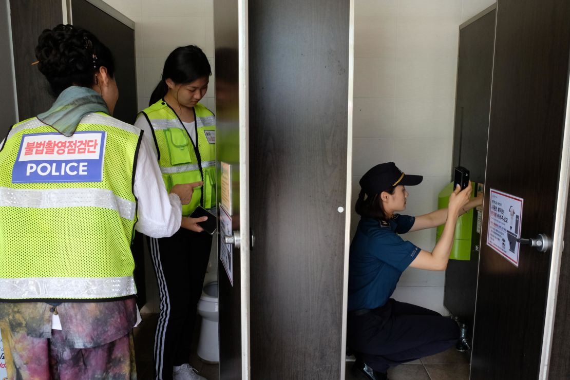 A hidden-camera search squad, consisting of student and citizen volunteers, scan a restroom near a public pool in Changwon, South Korea on July 25, 2018.