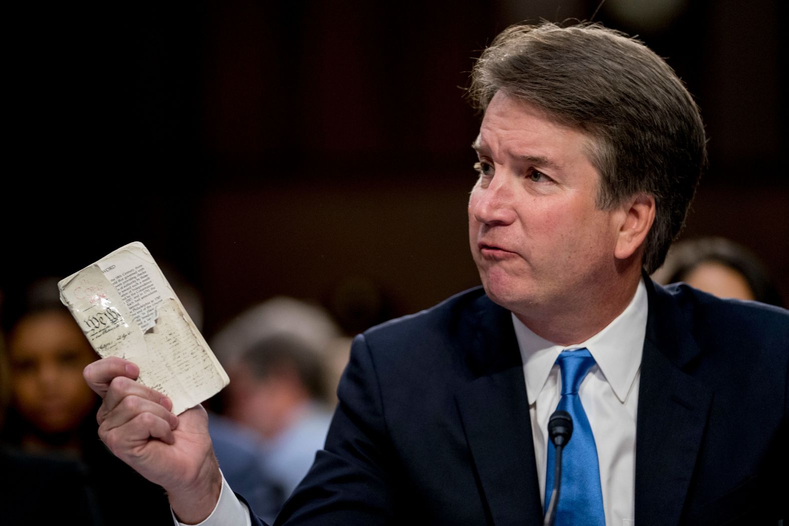Kavanaugh holds up a worn copy of the Constitution during his testimony on Wednesday. "If confirmed to the Supreme Court and as a sitting judge, I owe my loyalty to the Constitution," he said. "That is what I owe loyalty to. And the Constitution establishes me as an independent judge bound to follow the law as written."