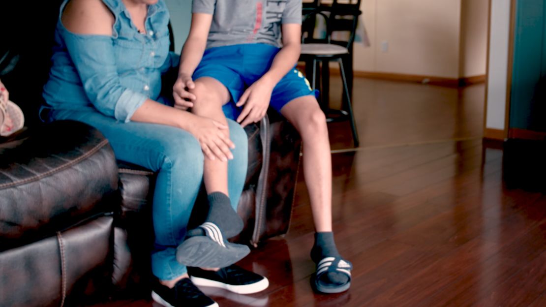 Alejandro's mother Dalia, left, wears an ankle monitor as authorities process her request for asylum.