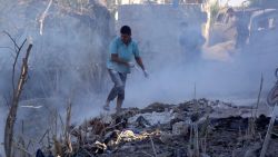 Syrians use dirt to put out a fire at the scene of a reported air strike in the district of Jisr al-Shughur, in the Idlib province, on September 4, 2018. - Russian warplanes battered Syria's rebel-controlled northwestern Idlib province on September 4 for the first time in three weeks, the Syrian Observatory for Human Rights reported, as fears of a government offensive mount. (Photo by Zein Al RIFAI / AFP)        (Photo credit should read ZEIN AL RIFAI/AFP/Getty Images)