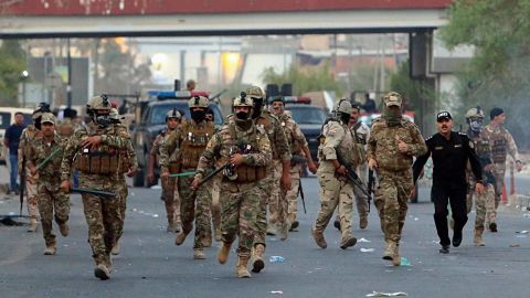 Security forces prepare to disperse protesters Sunday from outside a provincial council building.