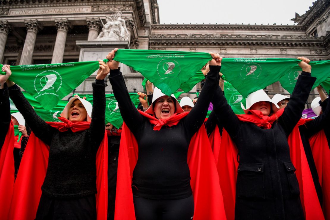 Activists in favor of the legalization of abortion disguised as characters from "The Handmaid's Tale" display green headscarves as they perform outside the National Congress in Buenos Aires, Argentina, on July 25, 2018.