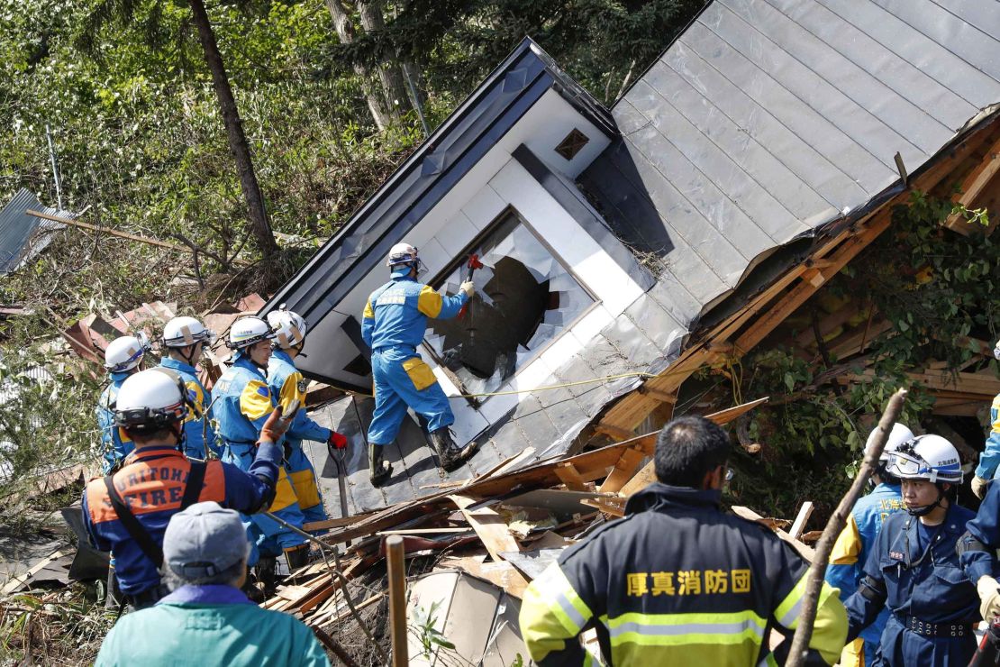 Police search for missing persons around a house destroyed by a landslide after a powerful earthquake in Atsuma, Hokkaido, northern Japan.